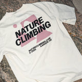 White t-shirt with 'Nature Climbing' text and logo on a stone surface