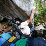 Girl climbing a rock face with greenery in the background