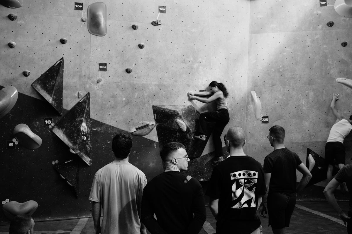 Climbers watching a session at a bouldering gym